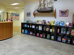 Spacious lobby with many books on our library shelves.
